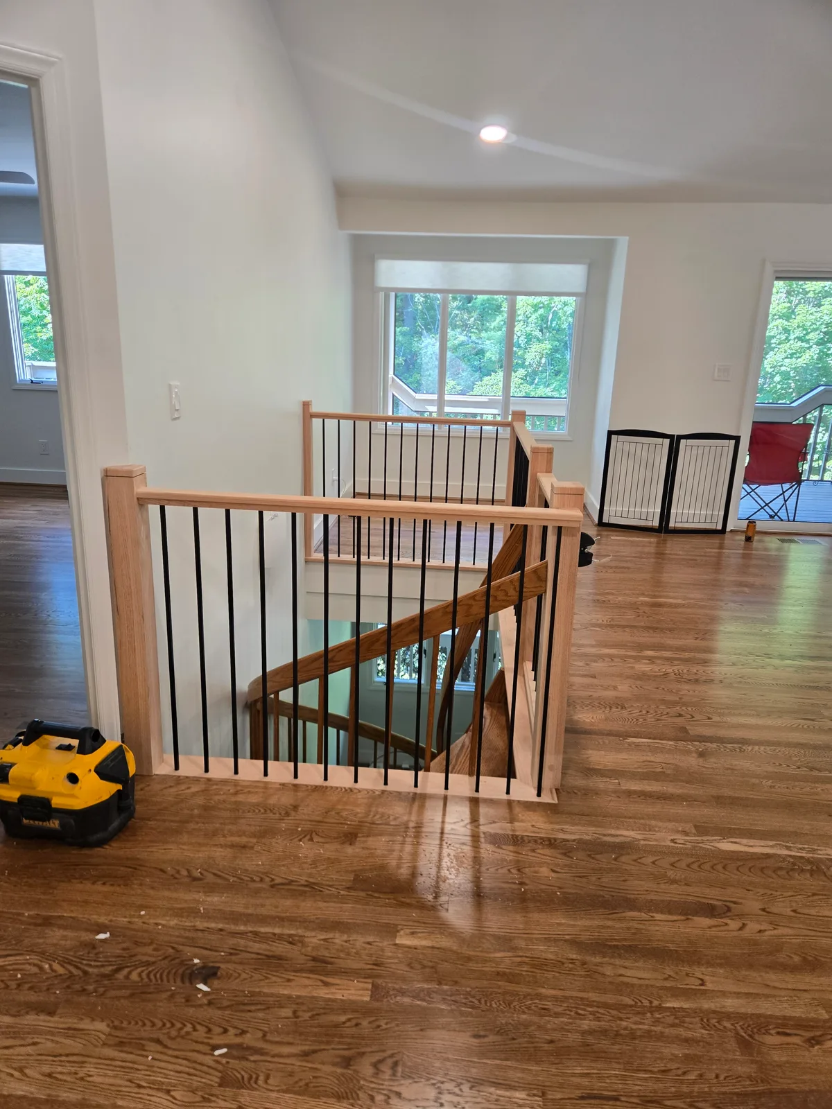 Finished interior stair railing with wood posts and black balusters
