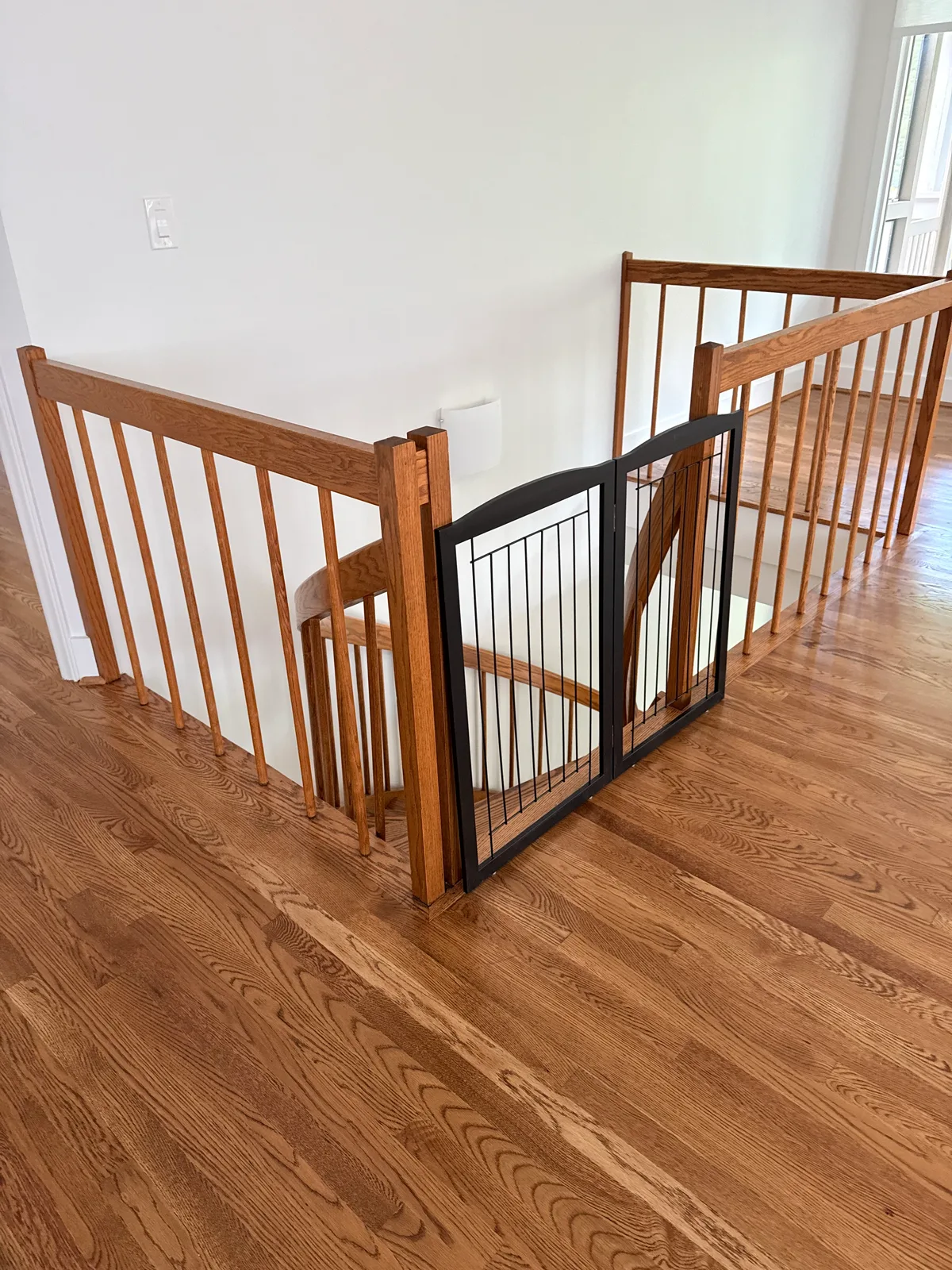 Interior wood stair railing before replacement viewed from the upper landing