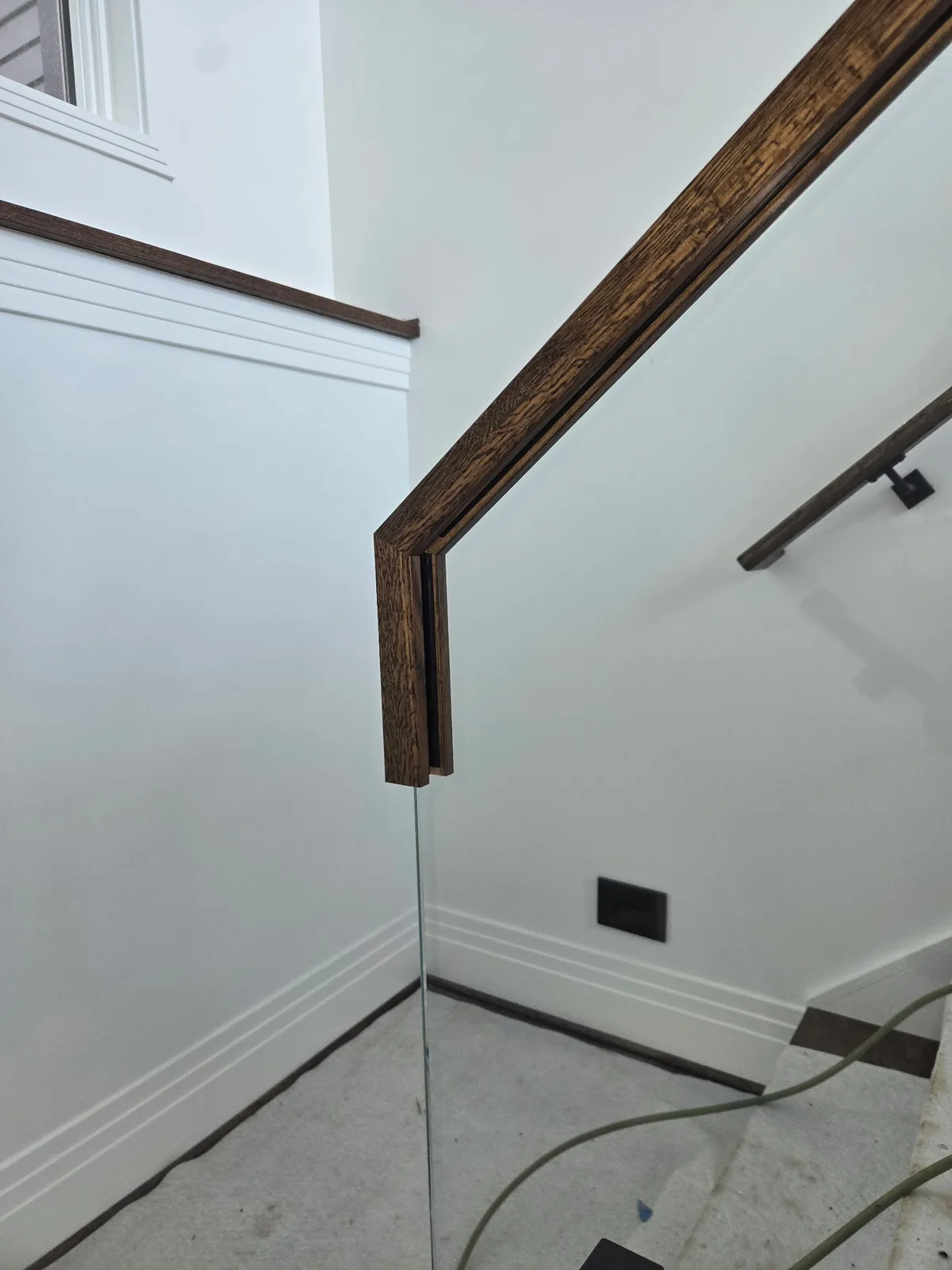 Viewrail glass stair railing with dark wood handrail