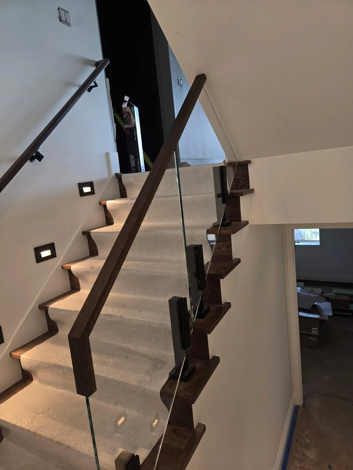 Finished Viewrail glass railing and wood handrail on an interior stair